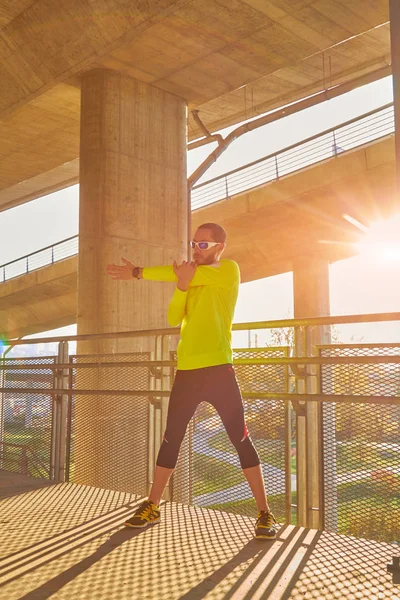 Sportovec pracující na velkém městském mostě. — Stock fotografie