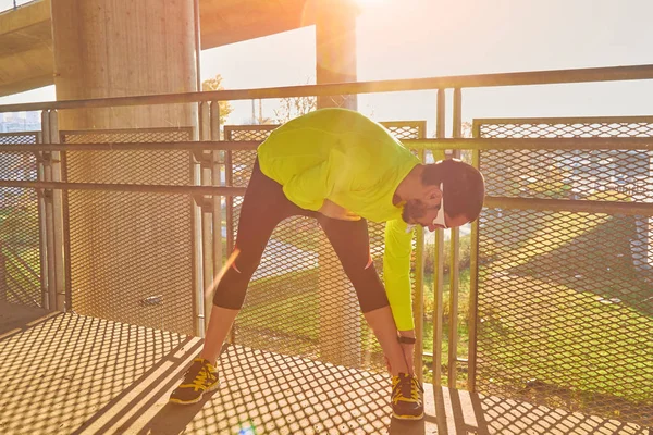 Sportovec pracující na velkém městském mostě. — Stock fotografie