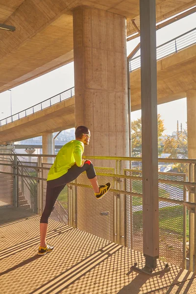 Sportovec pracující na velkém městském mostě. — Stock fotografie