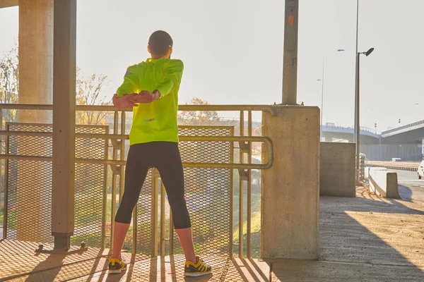 Sportovec pracující na velkém městském mostě. — Stock fotografie