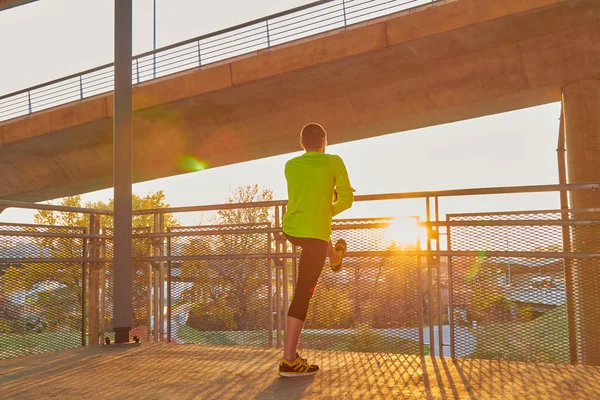 Sportovec pracující na velkém městském mostě. — Stock fotografie