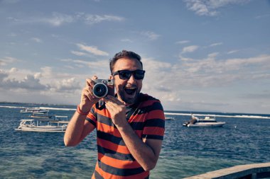 Bir okyanus/deniz tatil Vintage Film Kamera kullanan adam.