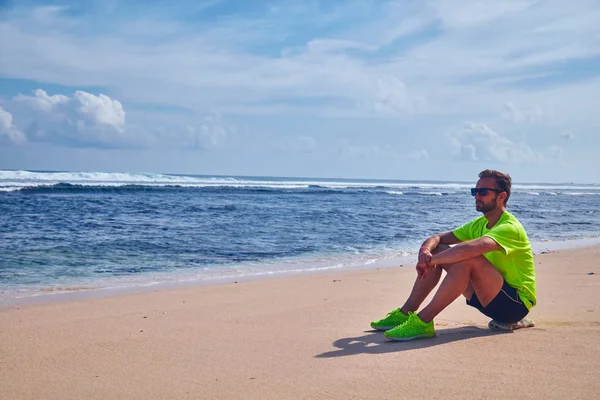 Sportsman s'étirant sur une plage tropicale exotique après le jogging / — Photo