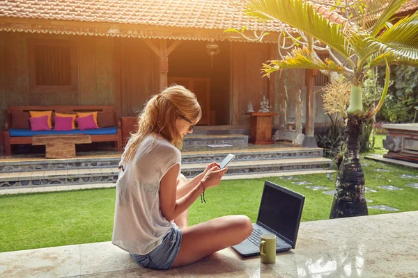 Freelance fille avec smartphone, café / thé et ordinateur portable sur une ho — Photo