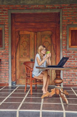 Akıllı telefon, kahve / çay ve dizüstü bilgisayar ile Freelancer kız bir ho