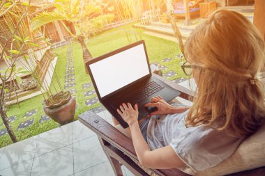 Kız bir ev veranda / terasta dizüstü bilgisayar kullanarak.