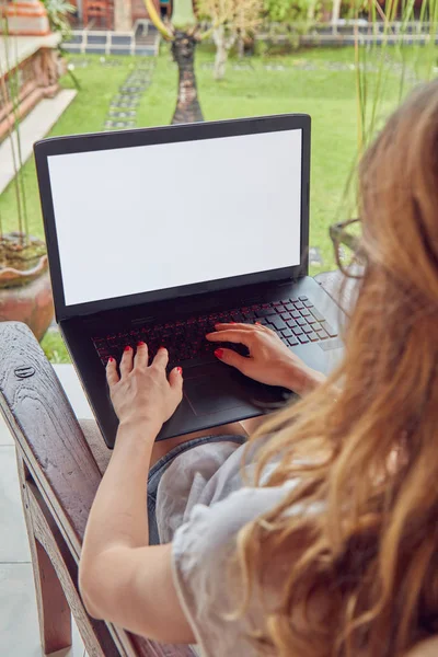 Дівчина використовує ноутбук на домашньому ганку / терасі . — стокове фото