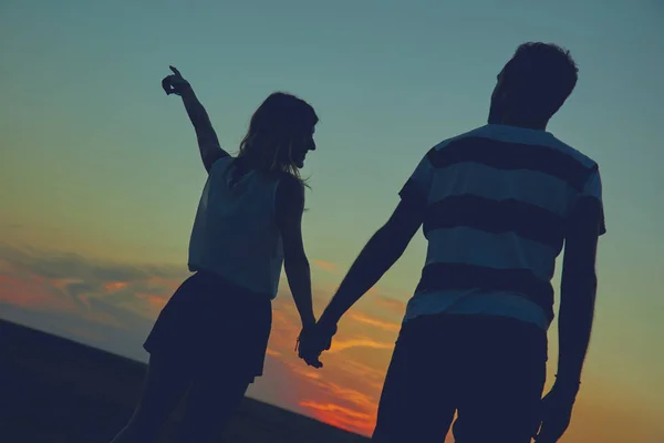 Silhouettes of a couple in sunset / sunrise time. — Stock Photo, Image