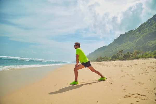 Sportivo che si estende su una spiaggia di sabbia tropicale . — Foto Stock