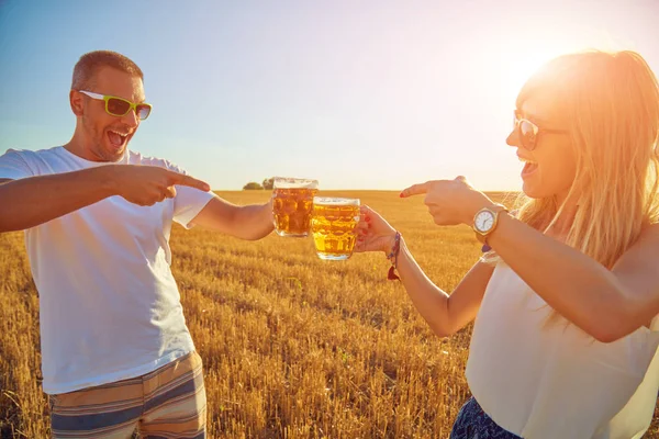 Pareja joven bebiendo cerveza al aire libre y disfrutando del verano . — Foto de Stock