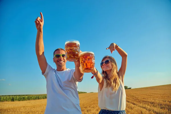 Giovane coppia bere birra all'aperto e godersi l'estate . — Foto Stock