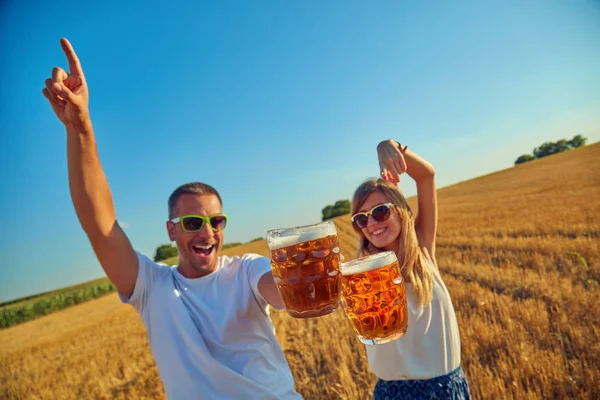 Giovane coppia bere birra all'aperto e godersi l'estate . — Foto Stock