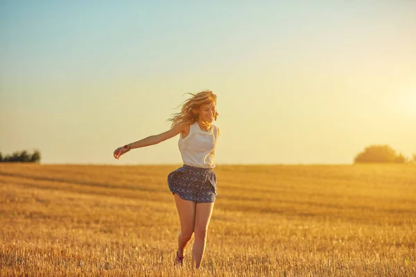 Carina giovane donna che salta in un campo di grano . — Foto Stock