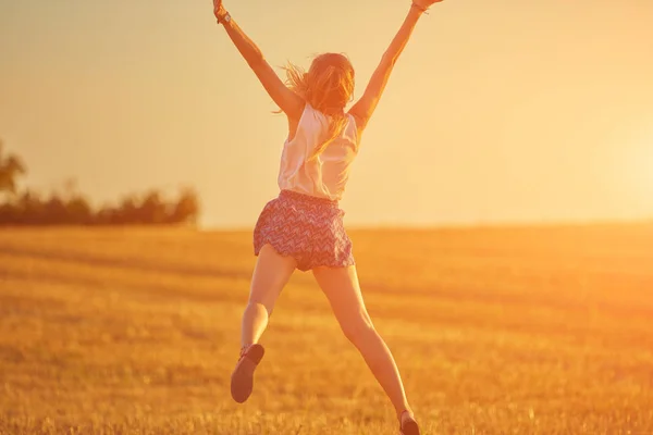 Cute young woman jumping in a wheat field. — Stock Photo, Image
