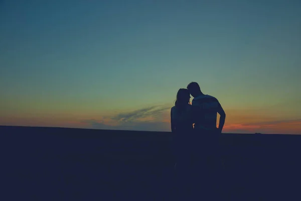 Siluet pasangan dalam waktu matahari terbenam / matahari terbit. — Stok Foto