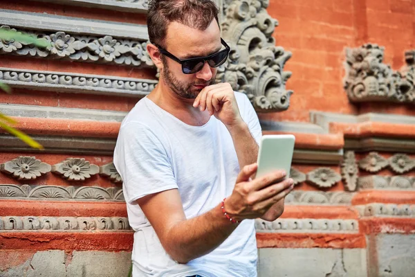 Hombre con gafas de sol y camisa de verano con smartphone . — Foto de Stock