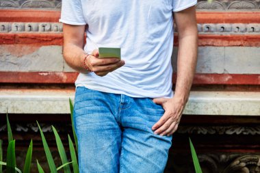 Yaz açık havada akıllı telefon kullanan adam.