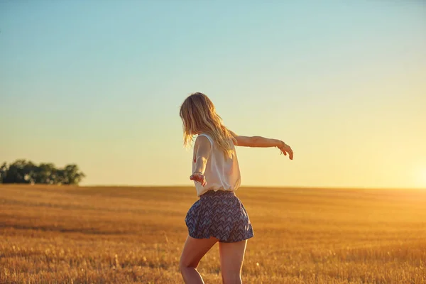 Мила молода жінка стрибає в пшеничному полі . — стокове фото