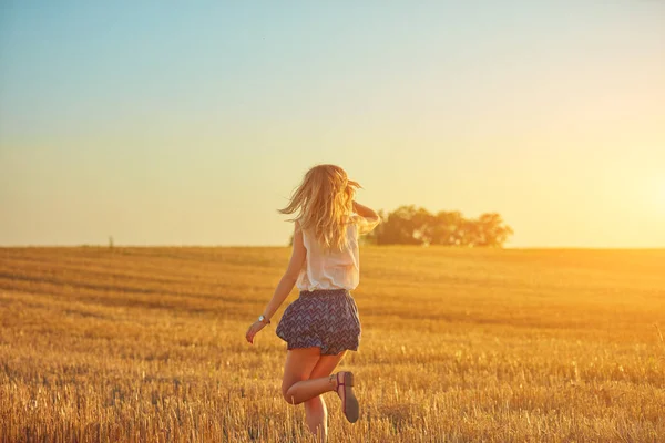 Мила молода жінка стрибає в пшеничному полі . — стокове фото