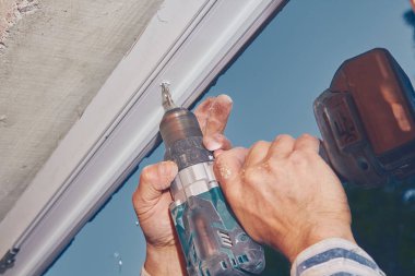 Pvc pencere fra içine vida için pil el matkap kullanarak Işçi