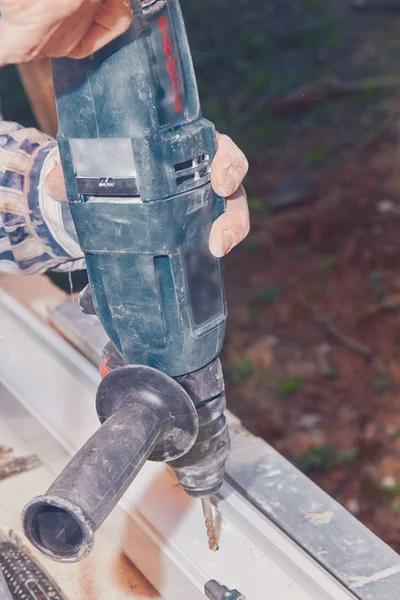 Worker using battery hand drill to screw into the PVC window fra — Stock Photo, Image