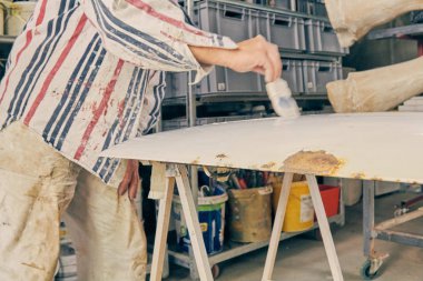 Yapay ahşap doku yapmak için boya fırçası kullanarak sanatçı.