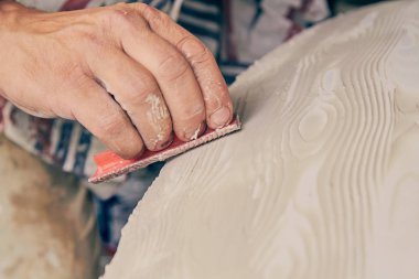 Yapay ahşap doku yapmak için boya fırçası kullanarak sanatçı.