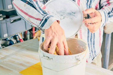 Yapay ahşap doku yapmak için boya fırçası kullanarak sanatçı.