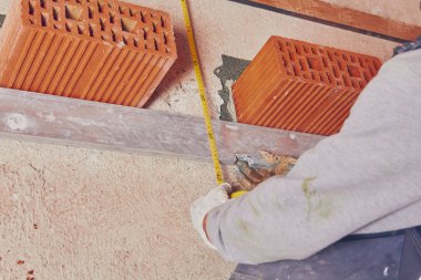 Gerçek inşaat işçisi örmek duvar kapalı.