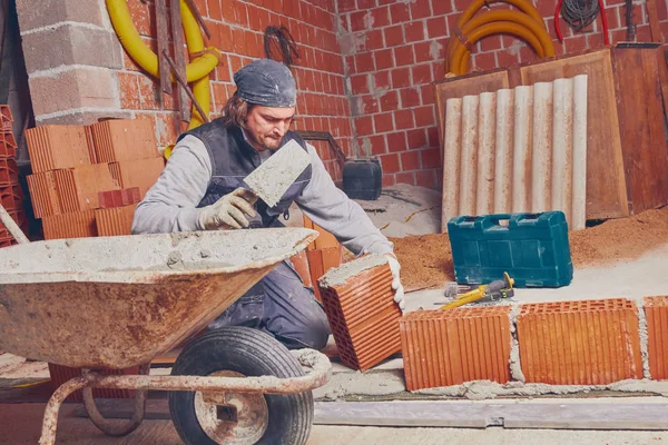 Véritable ouvrier de la construction maçonnant le mur à l'intérieur . — Photo