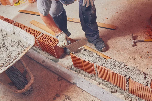 Pekerja konstruksi nyata batu bata dinding di dalam ruangan . — Stok Foto
