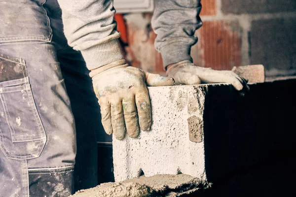 Pekerja konstruksi nyata batu bata dinding di dalam ruangan . — Stok Foto