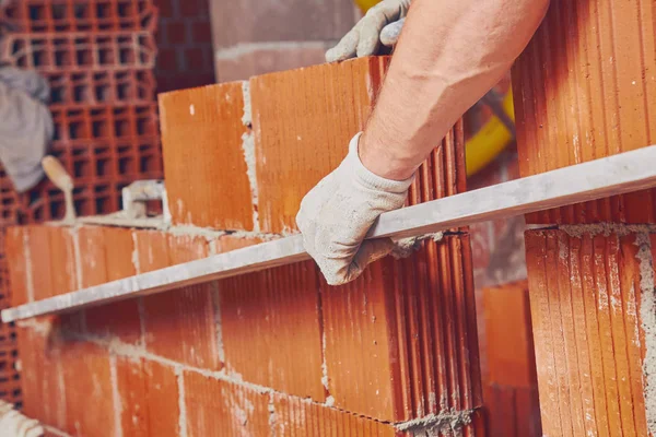 Real construction worker bricklaying the wall indoors. — Stock Photo, Image