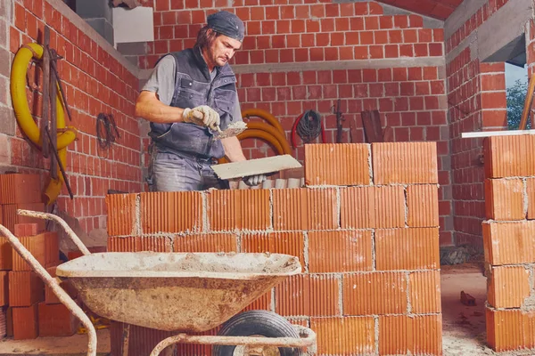 Véritable ouvrier de la construction maçonnant le mur à l'intérieur . — Photo