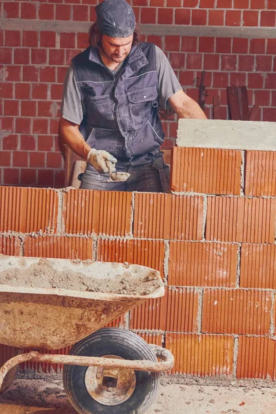 Véritable ouvrier de la construction maçonnant le mur à l'intérieur . — Photo