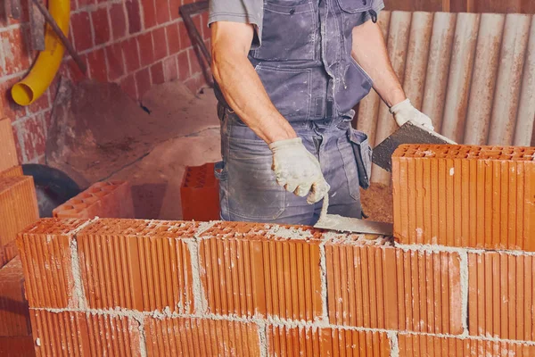 Πραγματική κατασκευή εργαζόμενος κτίσιμο τοίχου σε εσωτερικούς χώρους. — Φωτογραφία Αρχείου