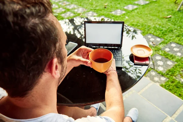 Hombre con café / té y portátil en un porche de casa . — Foto de Stock