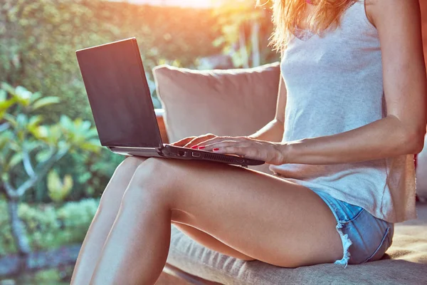 Meisje met laptop op een veranda thuis. — Stockfoto