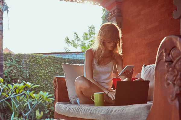 Mulher usando laptop, celular e beber café em um porc em casa — Fotografia de Stock