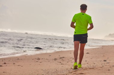 Adam çalışan/tropikal egzotik plajda koşu.