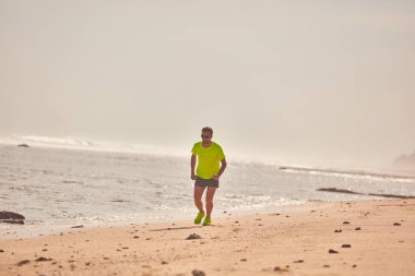 Adam çalışan/tropikal egzotik plajda koşu.