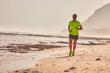 Adam çalışan/tropikal egzotik plajda koşu.