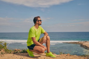 Okyanus yakınında tropikal egzotik uçurumun üzerinde uzanan Sportsman.