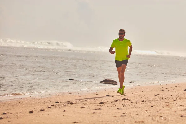 Adam çalışan/tropikal egzotik plajda koşu.