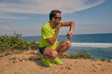 Okyanus yakınında tropikal egzotik uçurumun üzerinde uzanan Sportsman.