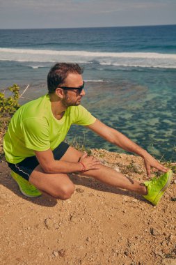 Okyanus yakınında tropikal egzotik uçurumun üzerinde uzanan Sportsman.