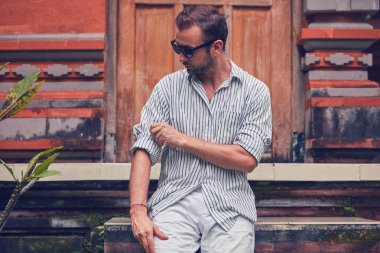 Adam bir ev veranda / veranda üzerinde oturan ve yaz zevk.