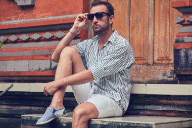 Adam bir ev veranda / veranda üzerinde oturan ve yaz zevk.