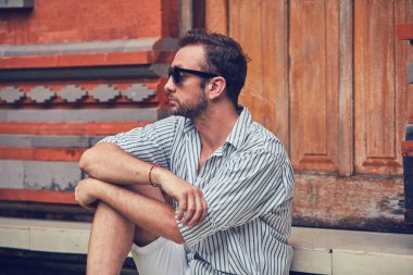 Adam bir ev veranda / veranda üzerinde oturan ve yaz zevk.