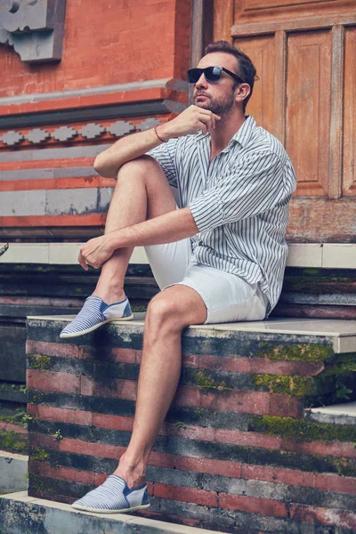 Man zittend op een huis patio/veranda en genieten van de zomer. — Stockfoto